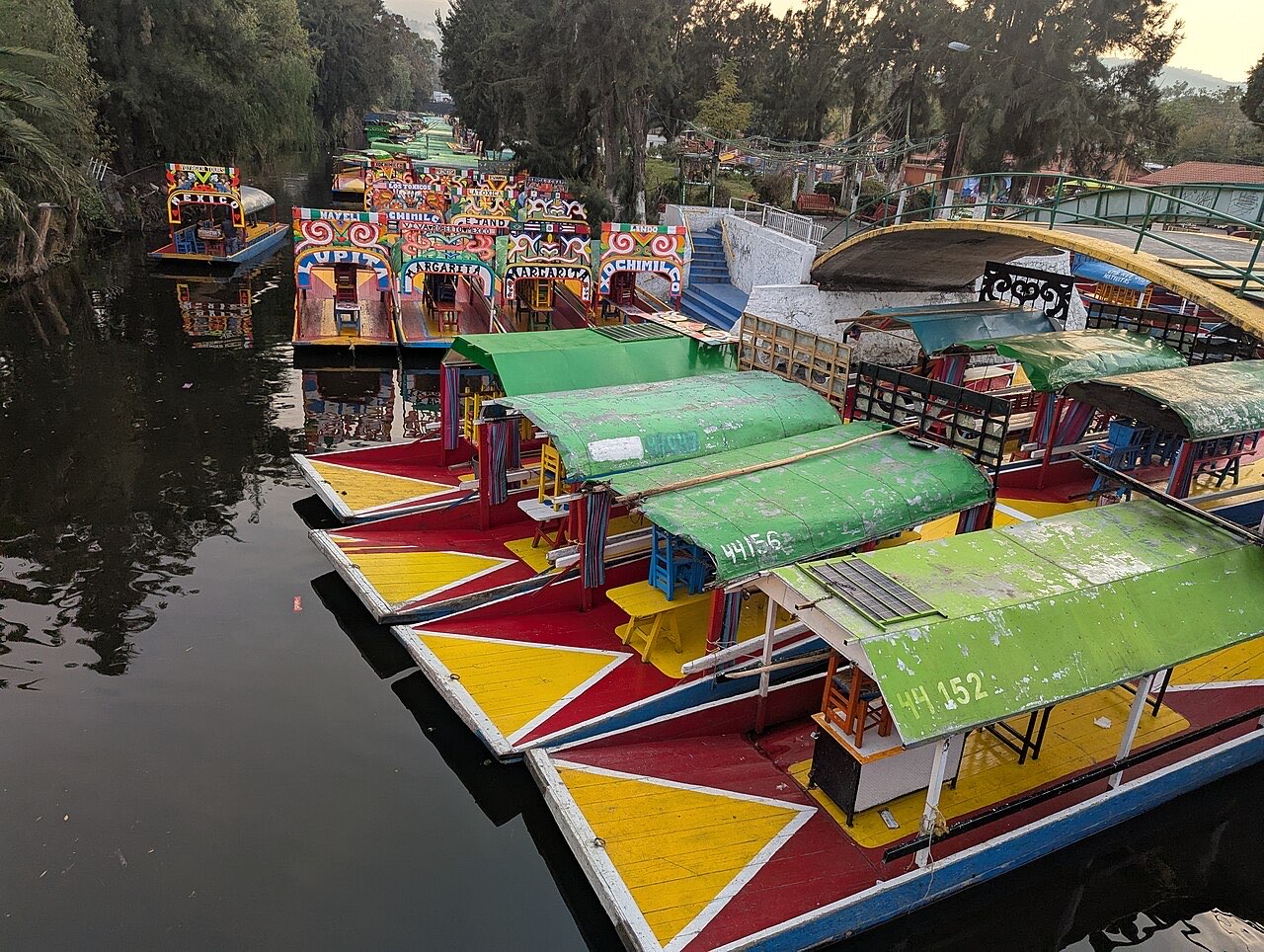 Painted trajinera boats lined up on a Xochimilco canal